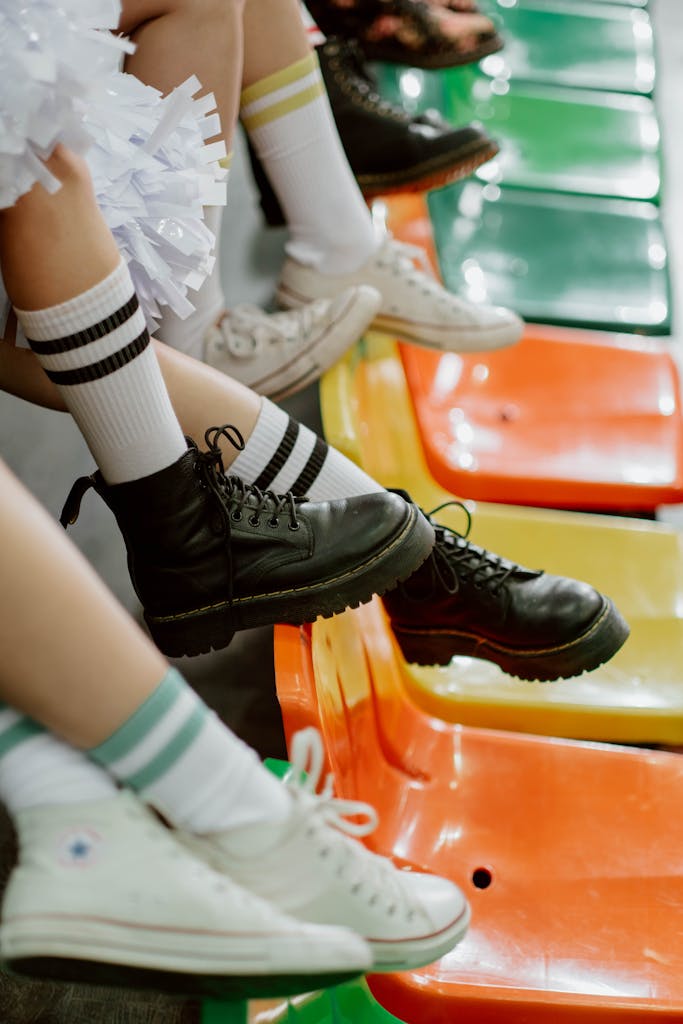A close-up shot of cheerleaders in colorful seating wearing trendy sneakers and knee socks.